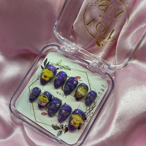 PumPur (S);Short Almond - Set med gulliga gelé press-on naglar i lila med glitter och swirl-mönster. Några naglar har söta 3D-figurer (pompompuri/sanrio) i gult och rött, bland annat cupcakes och tecknade ansikten. Naglarna är kort mandelformade och kommer i storlek S: 15 mm, 11,5 mm, 12 mm, 11 mm, 9 mm . Perfekt för dig som vill ha unika och färgglada naglar.