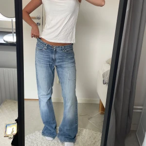 Lågmidjade ljusblåa bootcutjeans  - Säljer ett par ljusblå jeans från Jeans Only med klassisk femficksmodell och bootcut-ben. Jeansen har låg midja, slitningar på ena benet och snyggt tvättad denim. W30 L 32. Midjemåttet är 80cm och innerbenslängden är 77cm. Dom är lite för stora och långa för mig, (jag är 167cm)