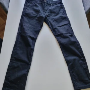 Svarta slim jeans Diesel Thommer - Svarta jeans från Diesel, modell Thommer. Slim-skinny passform med klassisk femficksdesign och stretchigt material för extra komfort. Snygg metallogo bak och diskreta sömmar. Perfekta för dig som gillar en smal siluett och stilren look.