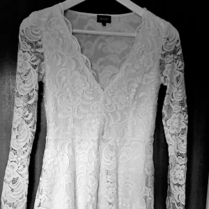 Vit spetsklänning med v-ringning - Superfin vit kortklänning från Bubbleroom i spets med blommigt mönster. Klänningen har v-ringad hals, långa ärmar och är utsvängd 🤍jag har använt den en gång och den är i väldigt bra skick! Skicka gärna prisförslag då jag vill få sålt den 💋