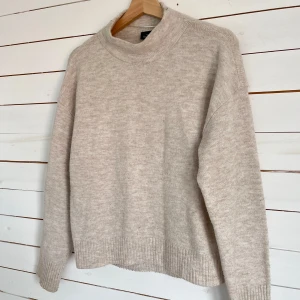 Beige stickad polotröja - Mysig beige stickad polotröja med ribbade muddar och avslut. Tröjan har en avslappnad passform och är perfekt för lager-på-lager. Enkel och stilren design som funkar till allt. Halsen är inte särkilt hög och sitter inte tajt vilket är väldigt skönt 💕