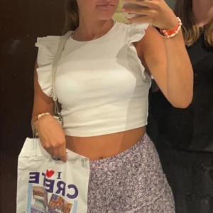 Vit topp med volangärmar - Säljer en vit croppad topp med breda volangärmar och rund halsringning. Toppen är från Zara, storlek S. Perfekt att matcha med både jeans och kjol. 