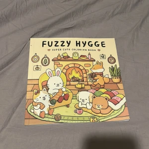 Fuzzy Hygge: Super Cute Coloring Book - En supergullig målarbok fylld med mysiga illustrationer av djur som chillar tillsammans. Perfekt för dig som älskar söta motiv och vill koppla av med färgläggning. Skapa din egen hygge-stämning och låt kreativiteten flöda! (Har rivit ut dom sidorna jag målat)