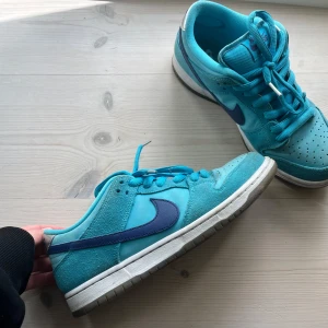 Nike SB Dunk Low Pro - Supercoola dunks o färgen ”Blue Fury” i storlek 41 (US 8). De är köpta för 2850kr från Stockx och vid köp medföljer extra skosnören, äkthetsbevis, kvitto och orginalbox! Är i bra skick men med lite smuts på ett fåtal ställen så som på hälen men går nog att tvätta bort!