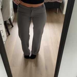 Grå raka byxor med låg midja - Säljer ett par stilrena grå kostymbyxor med låg midja och raka ben.  från Nelly I storlek S  anvönd Nån gång men aldrig använt mer 