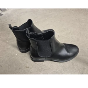 Ankelboots - Eleganta svarta ankelboots med dragkedja på sidan och resår. Perfekta för både vardag och fest. Använd endast 2 gånger.