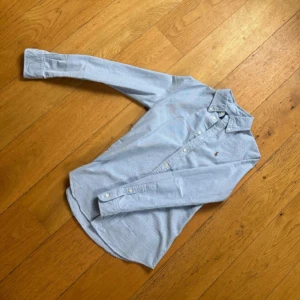 Ralph Lauren Skjorta (pris diskuterbart) - !! NY SKICK !! Snygg ljusblå skjorta från Ralph Lauren i custom fit sitter SLIM FIT med klassisk button-down krage och broderad logga på bröstet. Skjortan har lång ärm, normal passform och är tillverkad i mjuk bomull. Perfekt till jeans för en clean och stilren look.