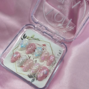 MermaidSprinkle (S);Short Almond;Curved - Set gelé lösnaglar i rosa och vitt med glitter, pärlor och 3D-effekter. Naglarna har söt havsinspirerad design med snäckor och blommor i skimrande pastellfärger. Kommer i storlek S: 15 mm, 11,5 mm, 12 mm, 11 mm, 9 mm