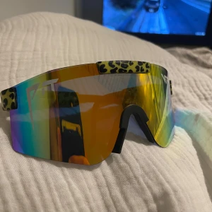 Pit Vipers - Säljer ett par riktigt feta Pit Viper solglasögon med spegelglas i regnbågsfärger och leopardmönstrade detaljer på bågarna. Sparsamt använda