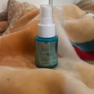 Moroccanoil Frizz Shield Spray 50ml - Moroccanoil Frizz Shield Spray i en smidig blå plastflaska med vit spraypump. Innehåller 50 ml och är perfekt för att tämja frissigt hår. Ger ett silkeslent resultat och är enkel att använda tack vare sprayfunktionen. Jag har använt den några gånger men it så mycket❤️