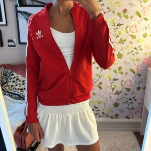 Adidasjacka - Röd adidas Jackan . Perfekt för en sportig och trendig look. Passar som en xs