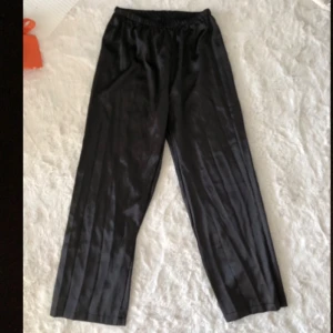 Svarta satin pyjamasbyxor  - Snygga svarta pyjamasbyxor med rak och vid passform i  satin material. Inte använda då dom är för små för mig på låren.