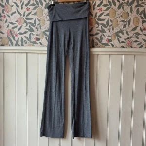 Grå vida byxor från Gina Tricot - Mysiga grå byxor från Gina Tricot med bred resår i midjan och riktigt vida ben. Tillverkade i mjukt och stretchigt material som känns skönt mot huden. Perfekta för en chill och avslappnad stil.