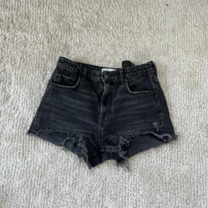 Svarta jeansshorts  - Snygga svarta jeansshorts. Klassisk femficksmodell med dragkedja och knapp framtill. Använda en gång, storlek 38. Har likadana i blått