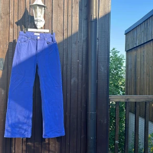 Blå wide jeans från Pull&Bear - Säljer ett par riktigt snygga blå jeans från Pull&Bear med breda ben och klassisk femficksdesign. Byxorna har hög midja och är gjorda i bomull, perfekta för dig som gillar en avslappnad och trendig look. Bootcut 