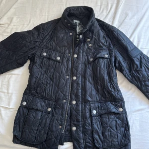 Svart quiltad jacka från Barbour M - Säljer en svart quiltad jacka från Barbour i storlek M. Säljer den för att den är för stor för mig. Riktigt snygg och skön speciellt nu till hösten. Inga slitningar som man ser, möjligtvis lite smutsig på nåt ställe.