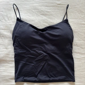 Svart linnetopp från Amisu XS - Säljer en svart linnetopp från Amisu i storlek XS. Toppen har tunna axelband och en lätt v-ringad halsringning. Modellen är croppad och sitter snyggt på kroppen. Perfekt att matcha med jeans eller kjol för en stilren look. Helt ny 