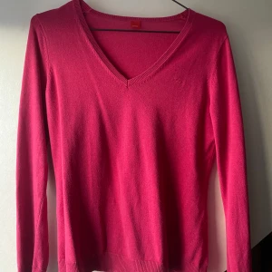 Rosa v-ringad tröja från Esprit - Snygg rosa v-ringad tröja från Esprit med lång ärm. Tröjan är i mjukt material och har ribbade muddar vid ärmslut och nederkant. 