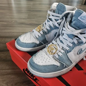 Nike Air Jordan 1 Denim Highs - Unika Nike Air Jordan 1 Highs med ljusblå denim och vitt skinn. Råa kanter på jeanstyget ger en cool, sliten look. Skorna har vita snören, perforerad tå och guldiga Jordan-detaljer på snörningen. Perfekta för dig som vill sticka ut med streetstyle. Bara lite slitna,  använda 2 gånger.  Köpta på Nike snkr, återförsäljare som "Wear the talk" säljer dem för 4880 idag