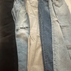 Samling av jeans i olika färger - 5 super fina jeans som tyvärr har blivit små på mig dom alla är i super fina skick ett par svarta lågmidjade ett par gråa med knappar där back ett par blåa vanliga som jag själv klipt hål i men det ser ut som dom är köpa osen två blåa jeans de en av dom är lite mer mörkblåa med knappar där back medans den andra är både knappar och hål, säljer helst alla tillsammans men om man är intresserad utan just ett par är det bara att kontakta 