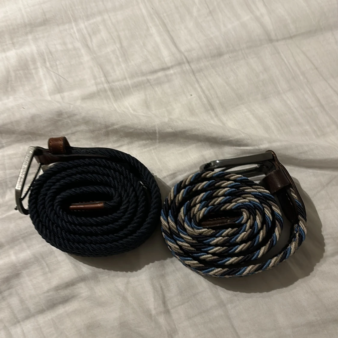 Två flätade bälten med metallspänne