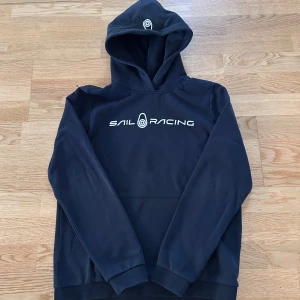 Svart Sail racing hoodie (Storlek 170) - En svart Sail racing hoodie i bra skick. Nypris: ca 800 kr. Använd fåtal gånger. (Storlek 170) 