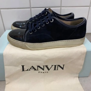 Mörkblå sneakers från Lanvin - Snygga sneakers från Lanvin med en stilren design. Skorna är i bra skick storleken är uk 7 passar dig som har 42 - 43 vanligtvis. Priset är kan diskuteras vid snabb affär. Har du några frågor är det bara höra av sig!
