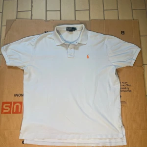 Ijusblå pikétröja från Ralph Lauren - Säljer en klassisk Ijusblå pikétröja från Ralph Lauren. Tröjan är tillverkad i 100% bomull och har en broderad logotyp på bröstet. Perfekt för en stilren och avslappnad look. Den är lite skadad på bilden(bild 5) Har du någon fråga svarar vi gärna på den! Priset kan alltid förhandlas 