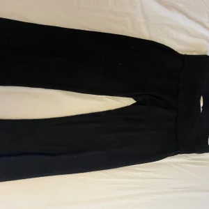 Svarta byxor från Gina Tricot - Snygga svarta byxor från Gina Tricot med ribbad midja. Perfekta för en stilren look och bekväma att bära hela dagen.