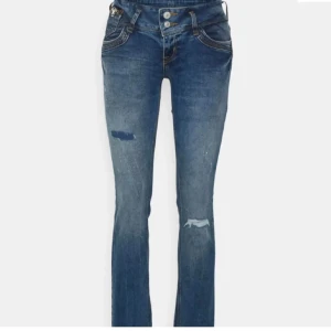 Blå jeans från LTB - Snygga blå jeans från LTB med slitna detaljer och en klassisk femficksdesign. De har en låg midja och en bootcut-stil som ger en avslappnad look. Perfekta för en casual outfit.