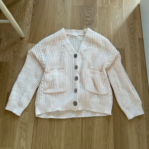 Beige stickad kofta - Mysig beige stickad kofta från Romwe med stora knappar och praktiska fickor framtill. Koftan har en ribbad struktur och långa ärmar. Aldrig använd 🩷