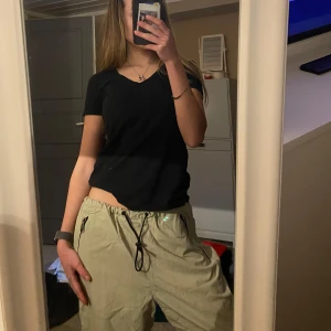 Beige/gröma cargopants med snörning - Säljer ett par beige cargopants med snörning i midjan. Byxorna har en loose passform och flera praktiska fickor. Byxorna kan man justera så skulle säga att det passar s-l