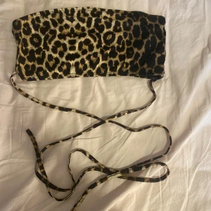 Leopardmönstrad tubtopp - Snygg leopardmönstrad tubtopp med snören som skall korsars över magen och knytas vid ryggen. Passar bra till både jeans och kjol.