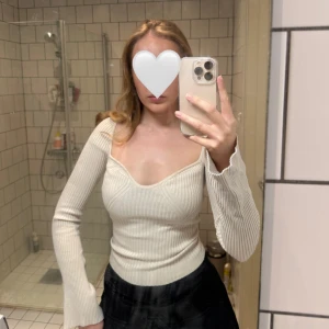 Beige ribbad topp - Säljer en beige ribbad topp med v-ringning och långa ärmar. Toppen har en figurnära passform och är perfekt för en stilren look.