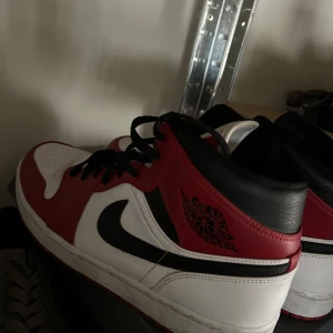 Air Jordan 1 mid chicago - Snygga Nike Air Jordans i klassisk röd och vit färgkombination med svarta detaljer. Perfekta för dig som vill ha en stilren och sportig look. Skorna kostar 2 599 i affär. Storlek 45. Pris kan diskuteras! 
