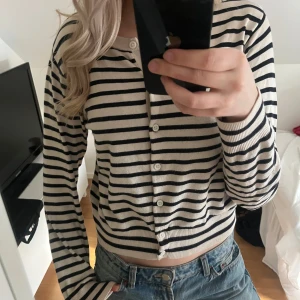 Randig kofta i beige och svart hm - Säljer en stilren randig kofta i beige och svart med knappar framtill. Super fin men kommer tyvärr inte till användning! Strl M🥰
