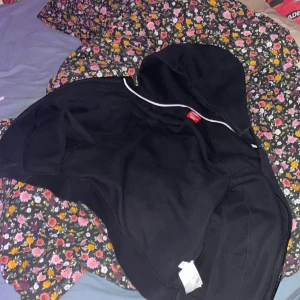 Svart hoodie från Nike - Säljer en svart hoodie från Nike med dragkedja och huva. Perfekt för en avslappnad stil. Den har praktiska fickor och en klassisk design.