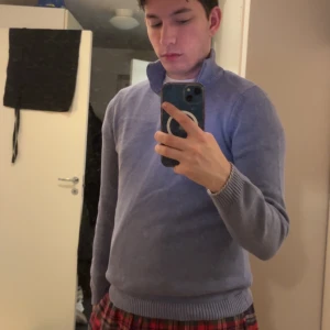 Lila polotröja - Säljer en stilren lila polotröja med ribbade muddar vid ärmslut och nederkant. Perfekt för kyligare dagar och ger en klassisk look. Passar bra till både jeans och chinos.