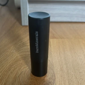 Läppstift från bareMinerals - Snyggt läppstift från bareMinerals i en mjuk rosa nyans. Kommer i en elegant svart hylsa med märkets logga tryckt på sidan. Kan även användas som en blush, pris går att diskutera🩷