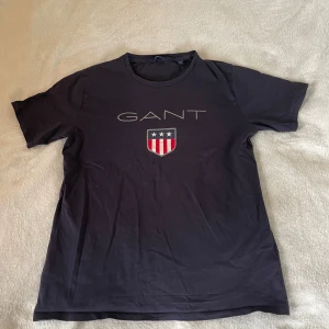 Mörkblå t-shirt från GANT - Säljer en mörkblå T-shirt från GANT i storlek 176 (sitter dock som S : se bild).