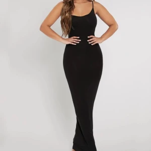 Svart klänning - Säljer denna eleganta långklänning med smala och justerbara axelband och figurnära passform. Perfekt för en stilren look inför sommaren!