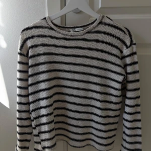 Randig tröja från Zara - Säljer en vit svart randig tröja från Zara i mycket bra skick💕luftigt stickad och skön att ha på vår/sommar 