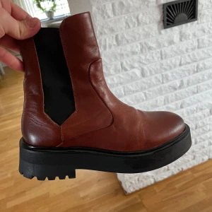 Bruna skinnboots med dragkedja - Snygga bruna boots i skinn med en robust sula och dragkedja på sidan. Väl omhändertagna. Från Sneaky Steve