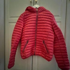 Rosa dunjacka från Colmar - Säljer en snygg rosa dunjacka från Colmar med dragkedja och två praktiska fickor framtill. Storlek 12år 154cm.