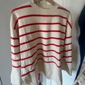 Randig tröja i rött och vitt - Säljer en snygg randig tröja i rött och vitt. Tröjan har långa ärmar och en rund halsringning. Perfekt för en avslappnad stil.