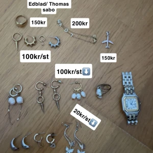 Smyckesamling med örhängen och armband - En samling av olika smycken inklusive örhängen och armband. Det finns flera par örhängen i olika stilar, inklusive guld- och silverfärgade med detaljer som stjärnor, pärlor och fjärilar. Ett armband med bokstäverna 'LOVE' i guldton finns också med. Pris står i bilderna