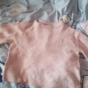 Rosa stickad tröja - Säljer en söt rosa stickad tröja i storlek XS. Tröjan har en enkel design med långa ärmar och en rund halsringning. Perfekt för kyligare dagar och lätt att matcha med olika outfits.