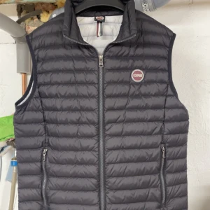 Svart dunväst från Colmar - Snygg svart dunväst från Colmat. Perfekt för lager-på-lager under kyliga dagar. Bra kvalité och bra passform. Använd ett fåtal gånger! Väldigt bra skick, 9/10 (Nästan 10/10) Storlek M. Passar i längd från 177-185 skulle ja gissa på. Passar perfekt nu till våren/sommaren!