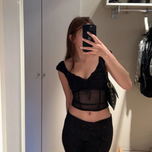 Svart mesh korsettopp - festtopp från urban outfitters i mesh i lite korsett stil som är såå så snygg!!