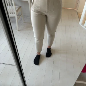 Beige kostymbyxor - Snygga beige kostymbyxor med hög midja och avsmalnande ben. 